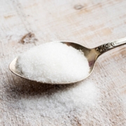 Image of sugar on a spoon, fructose is a natural sugar in which some people are intolerant to.