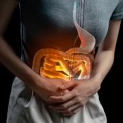 Man holding stomach in pain from a food intolerance. Digestive system on fire.