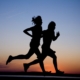 two people running infront of the sunrise