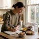Woman tracking food triggers in kitchen diary