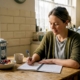 Woman updating her food diary in kitchen