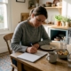 Woman tracking meals in kitchen diary