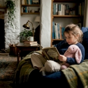Child reading quietly in a home corner