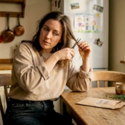 Woman collects hair sample at home kitchen table