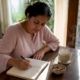 Woman recording food intolerance symptoms in diary