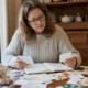 Woman reviewing food labels and diary at kitchen table