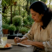 Woman logging health symptoms at kitchen table