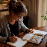 Woman reviewing FODMAP diet guide at kitchen table