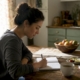 Woman writing food diary at kitchen table