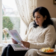 Woman reviewing histamine intolerance guide at kitchen table