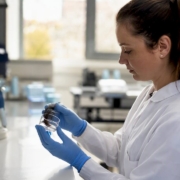 Close-up of blood sample tube in lab worker’s gloved hand