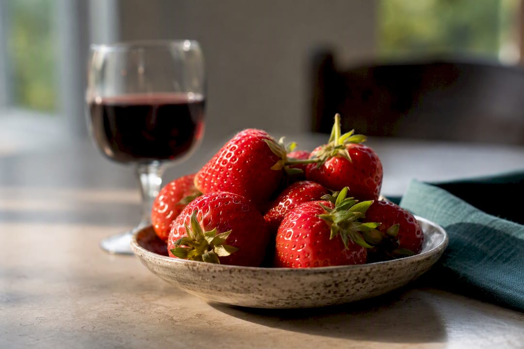 Strawberries and red wine on dining table