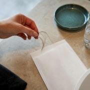 Hand placing hair strands into sample pouch