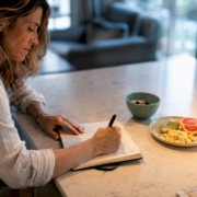 Woman tracking food symptoms in kitchen