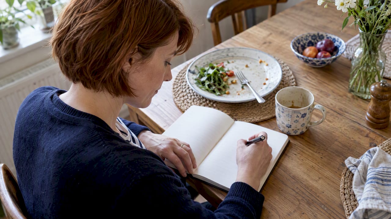 Hand recording food and symptoms in a diary
