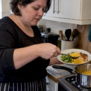 Woman preparing sweetcorn in a home kitchen