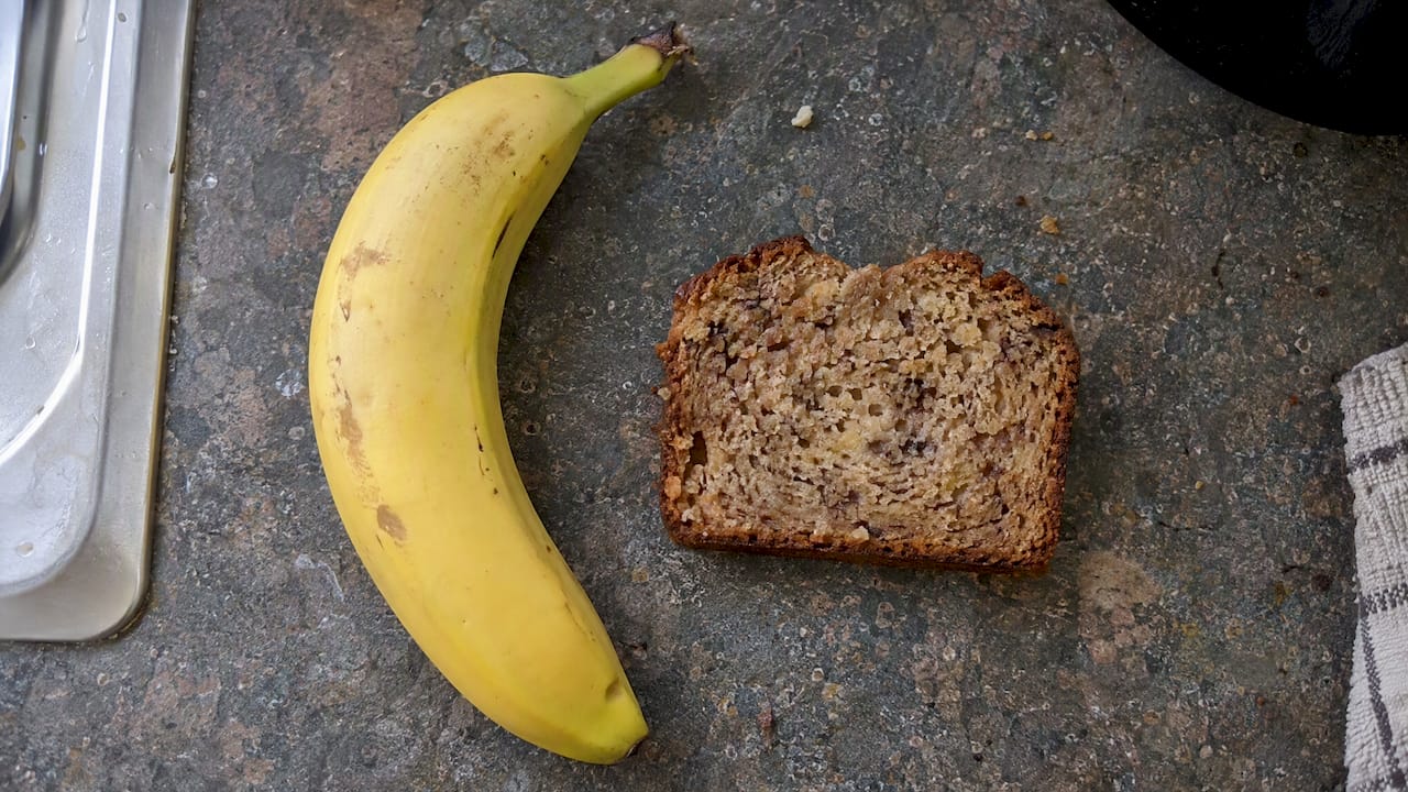 Raw banana beside a slice of banana bread