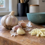 Whole and cut garlic on a kitchen board